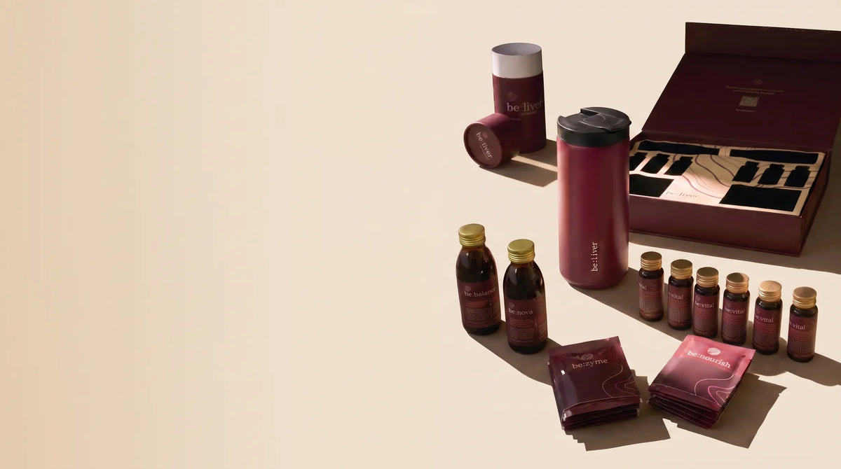be:liver kit with bottles, thermos, sachets and an open presentation box on a warm cream surface