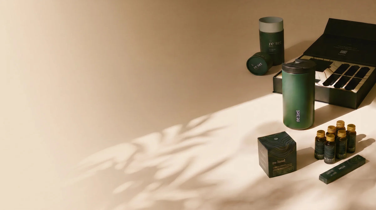 re:set kit with bottles, tumbler, re:load carton and an open presentation box on a warm cream surface