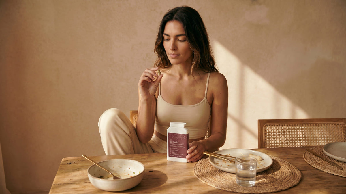 be:tavia capsules beside a glass of water on a kitchen counter